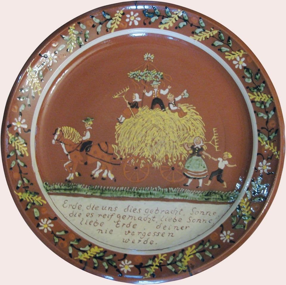 Teller mit Heuwagen, Pferd und Kindern, umlaufender Spruch, Blütenkranz am Rand.