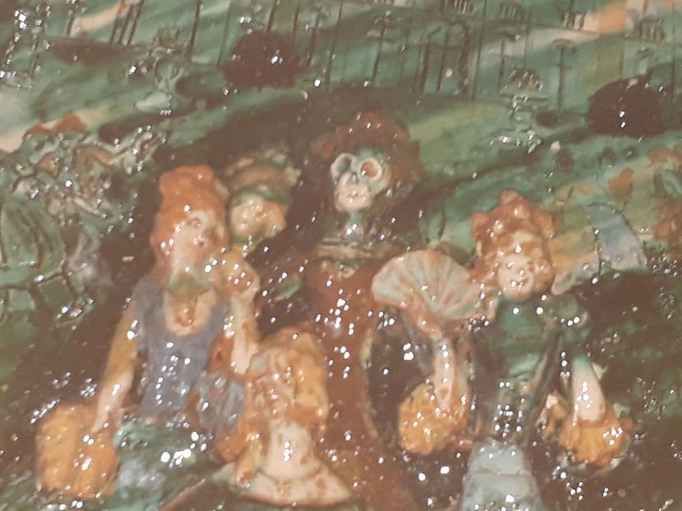 Detail nach dem Glasurbrand: Die Damen mit Fächern und das Skelett vor grün glasiertem Grund.