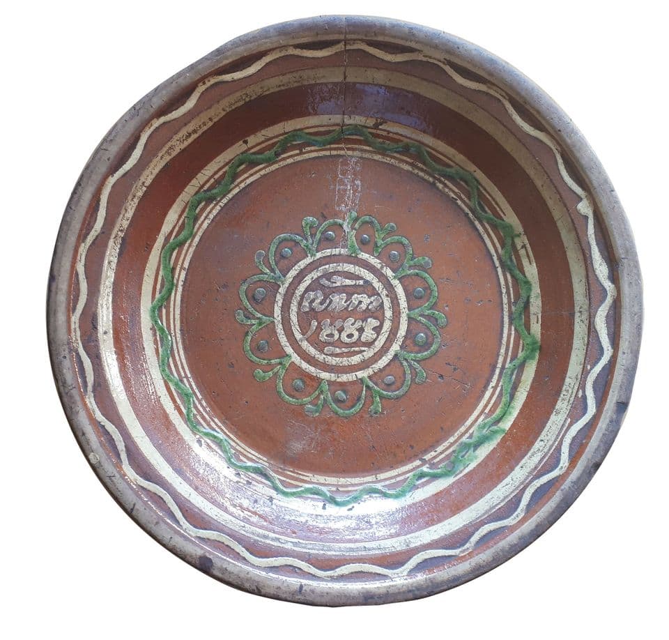Große Tönisberger Schüssel mit „Anno 1888“ im Spiegel, umgeben von grüner Blütenrosette und grünen und hellen Wellenbändern auf rotbraunem Grund.