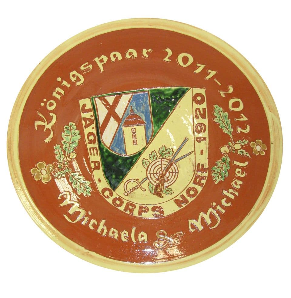 Teller für ein Schützenkönigspaar 2011/2012 mit bunt bemaltem Wappen des Jägercorps, Namen und Gründungsjahr auf rotbraunem Rand.