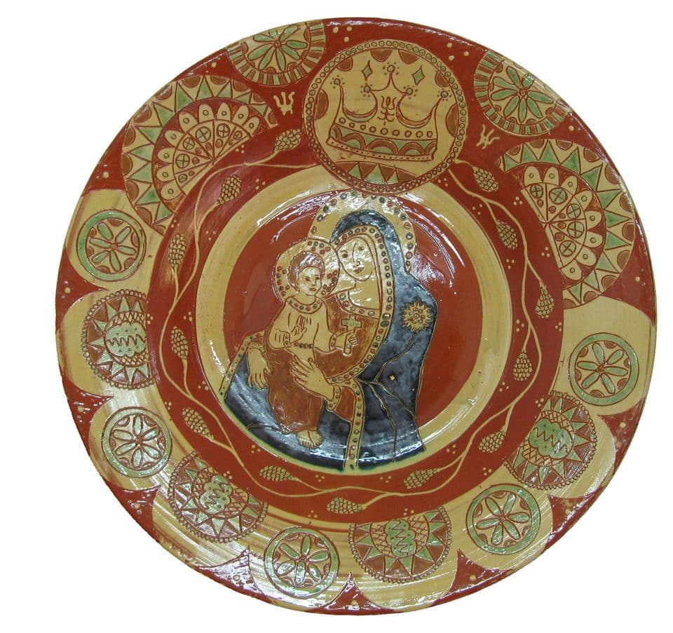 Teller mit Madonna in dunkelblauem Mantel und dem Kind mit Kreuz im Spiegel, darüber eine Krone, Rand mit Rosetten und Sonnenrädern in Ritztechnik.