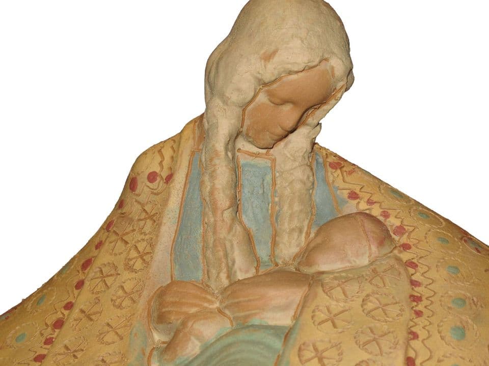 Detail einer unglasierten Mantelmadonna: Madonna mit langen Zöpfen und dem Kind im Arm, Mantel mit eingedrückten Ornamenten und farbigen Engobepunkten.
