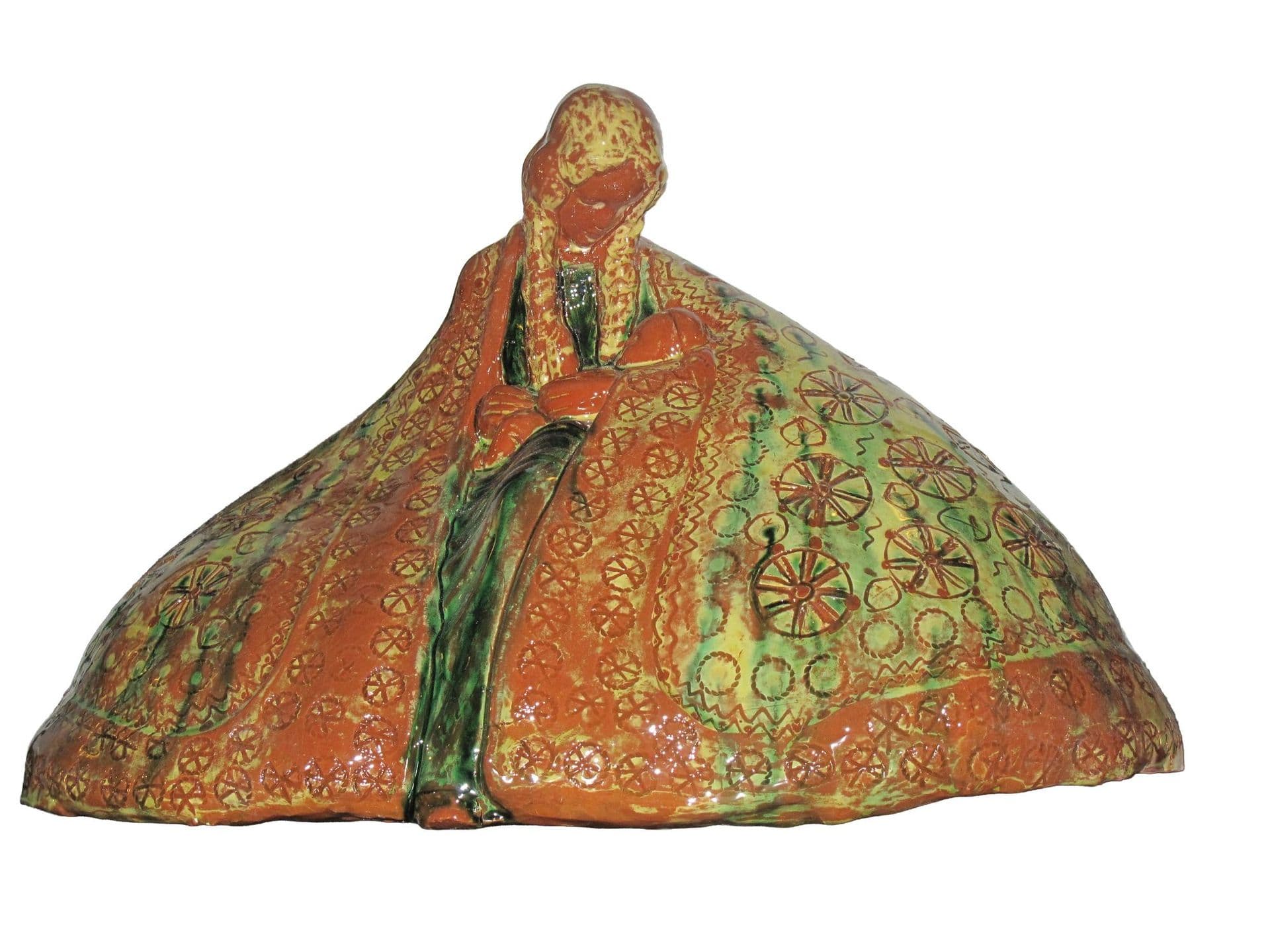 Mantelmadonna aus Irdenware: Ein weiter, orange und grün glasierter Mantel mit Rädchenornamenten fällt wie ein Zelt um die Figur.
