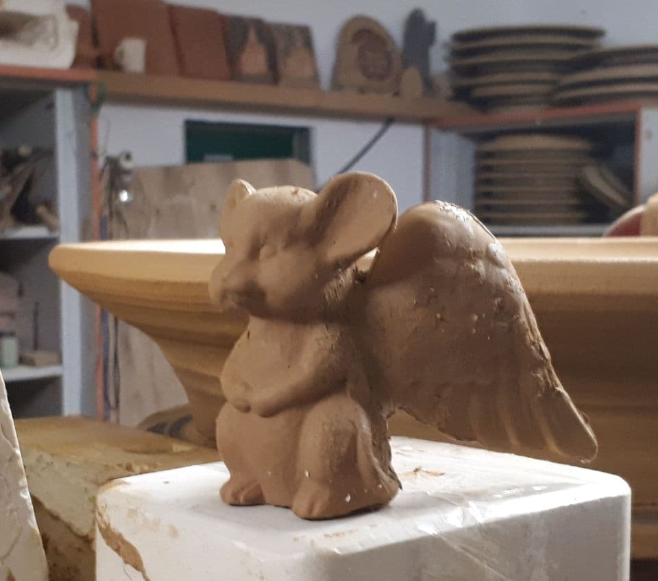Eine geflügelte Tonfigur, ein Engel in Mausgestalt, in der Werkstatt.