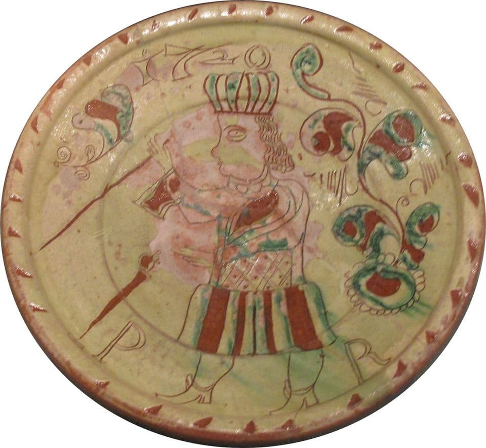 Tönisberger Teller von 1720 mit gekrönter Figur zwischen Blüten, Ritz- und Malhorndekor.