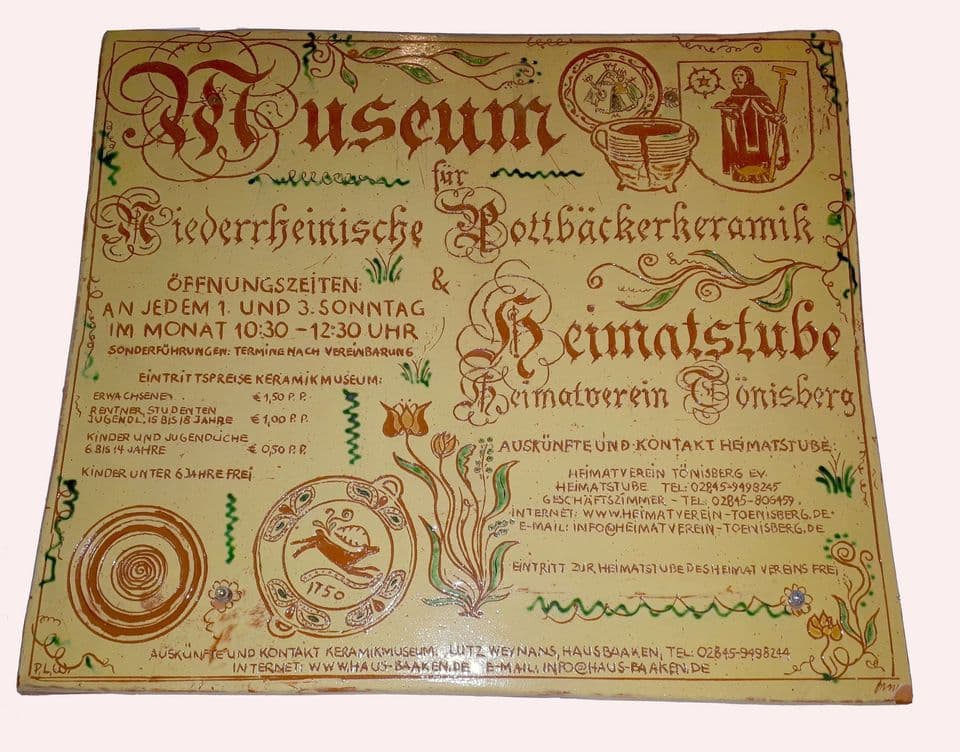 Keramikschild für das Museum für Niederrheinische Pottbäckerkeramik und die Heimatstube Tönisberg mit Öffnungszeiten, Schrift und Ornamenten in Braun und Grün.