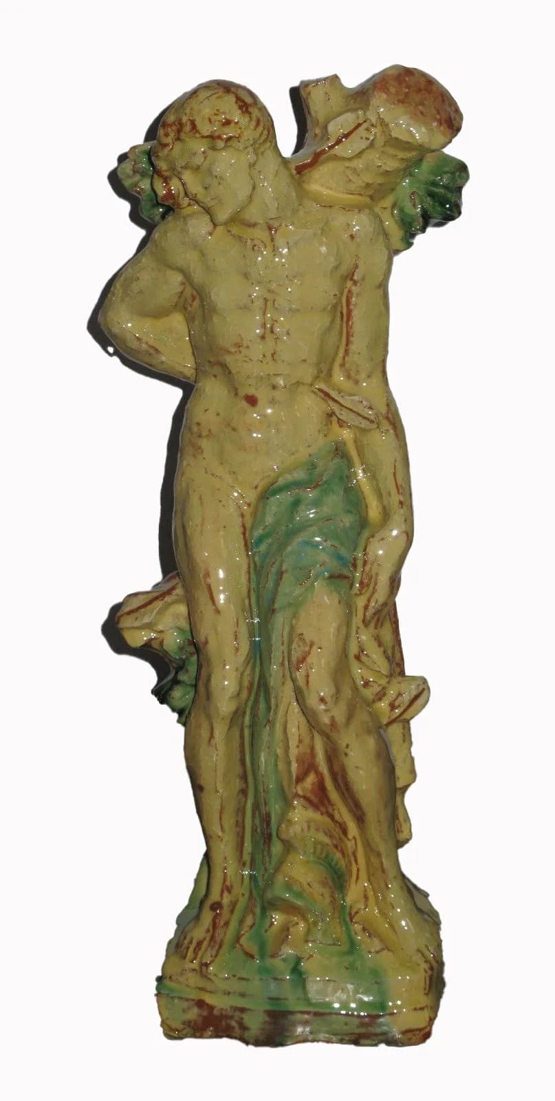 Heiliger Sebastian an einen Baumstamm gebunden, gelb und grün glasierte Figur, freigestellt.