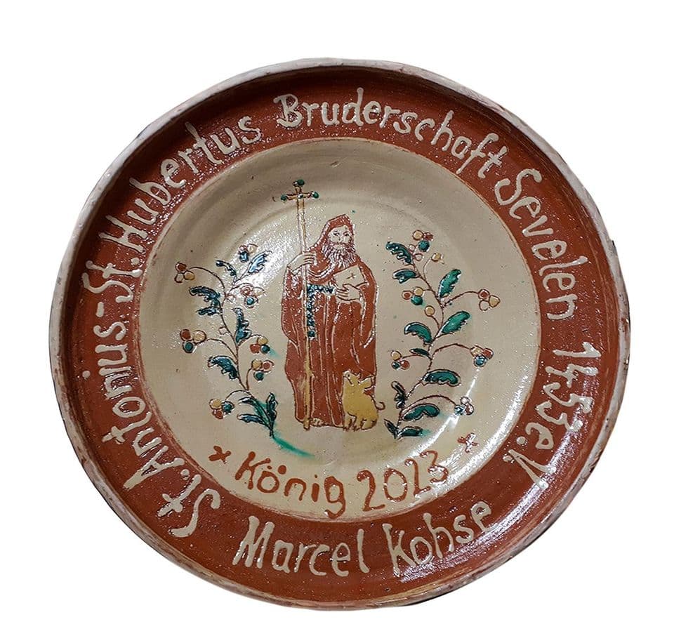 Königsteller der St.-Antonius-St.-Hubertus-Bruderschaft Sevelen: Heiliger im Spiegel zwischen Zweigen, Schrift auf braunem Rand, Jahr 2013.