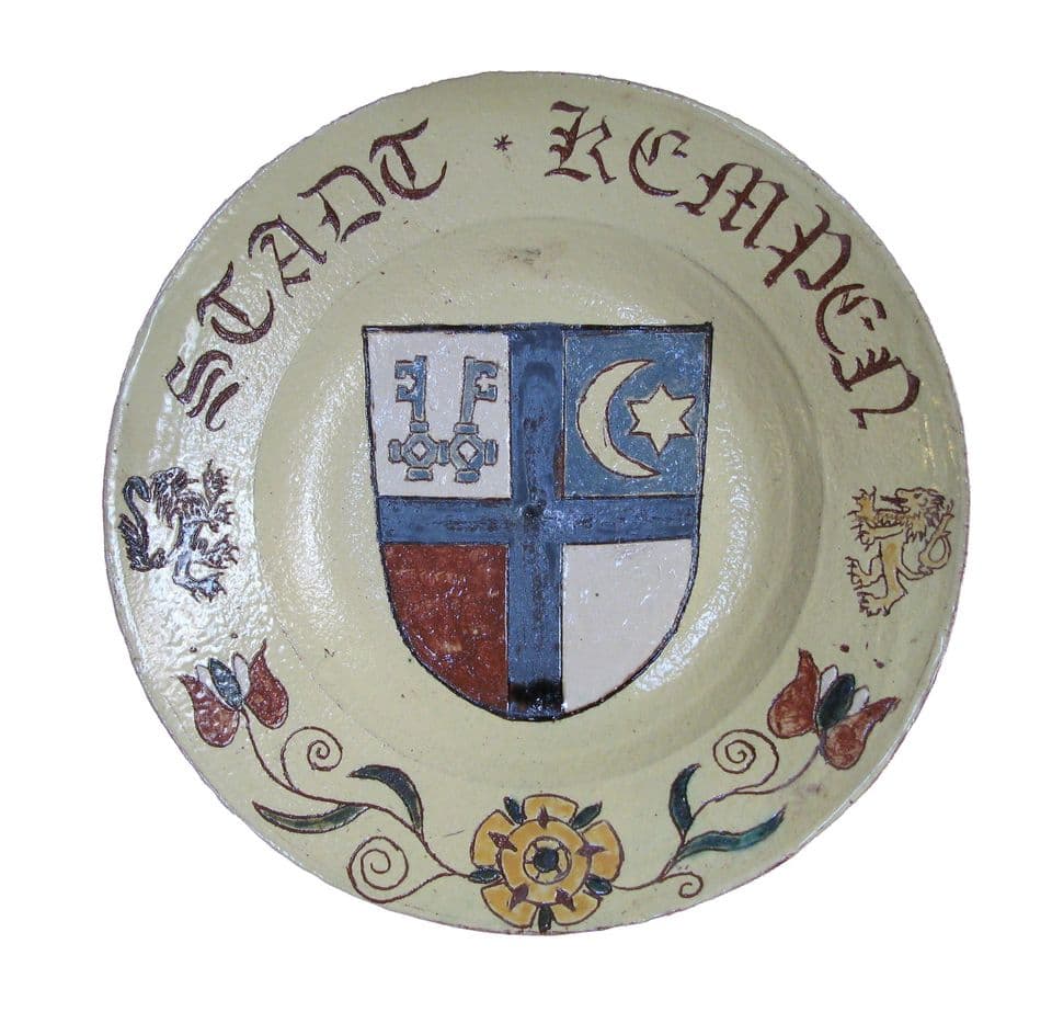 Teller mit Wappen der Stadt Kempen auf hellem Grund, Schriftzug „Stadt Kempen“ auf braunem Rand, dazwischen Tulpen.