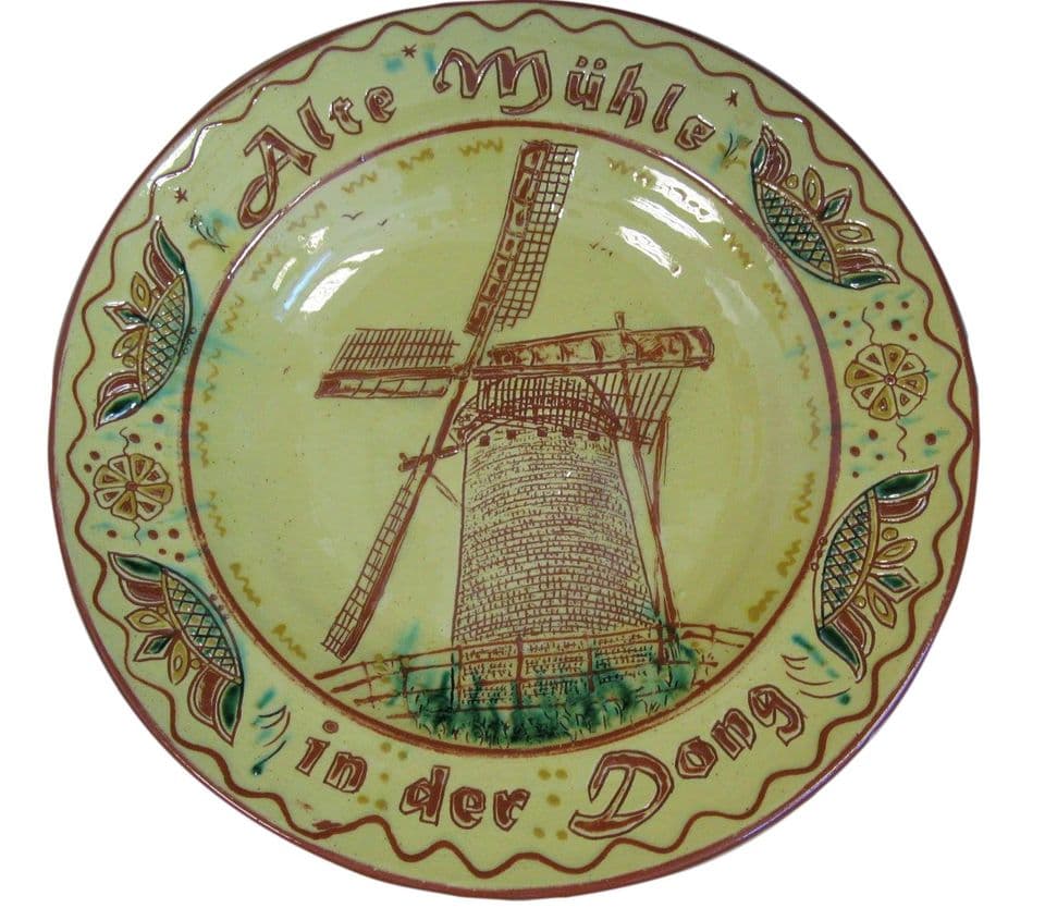 Teller mit Windmühle im Spiegel und dem Schriftzug „Alte Mühle in der Dong“, Rand mit Blattornamenten auf grüner Glasur.
